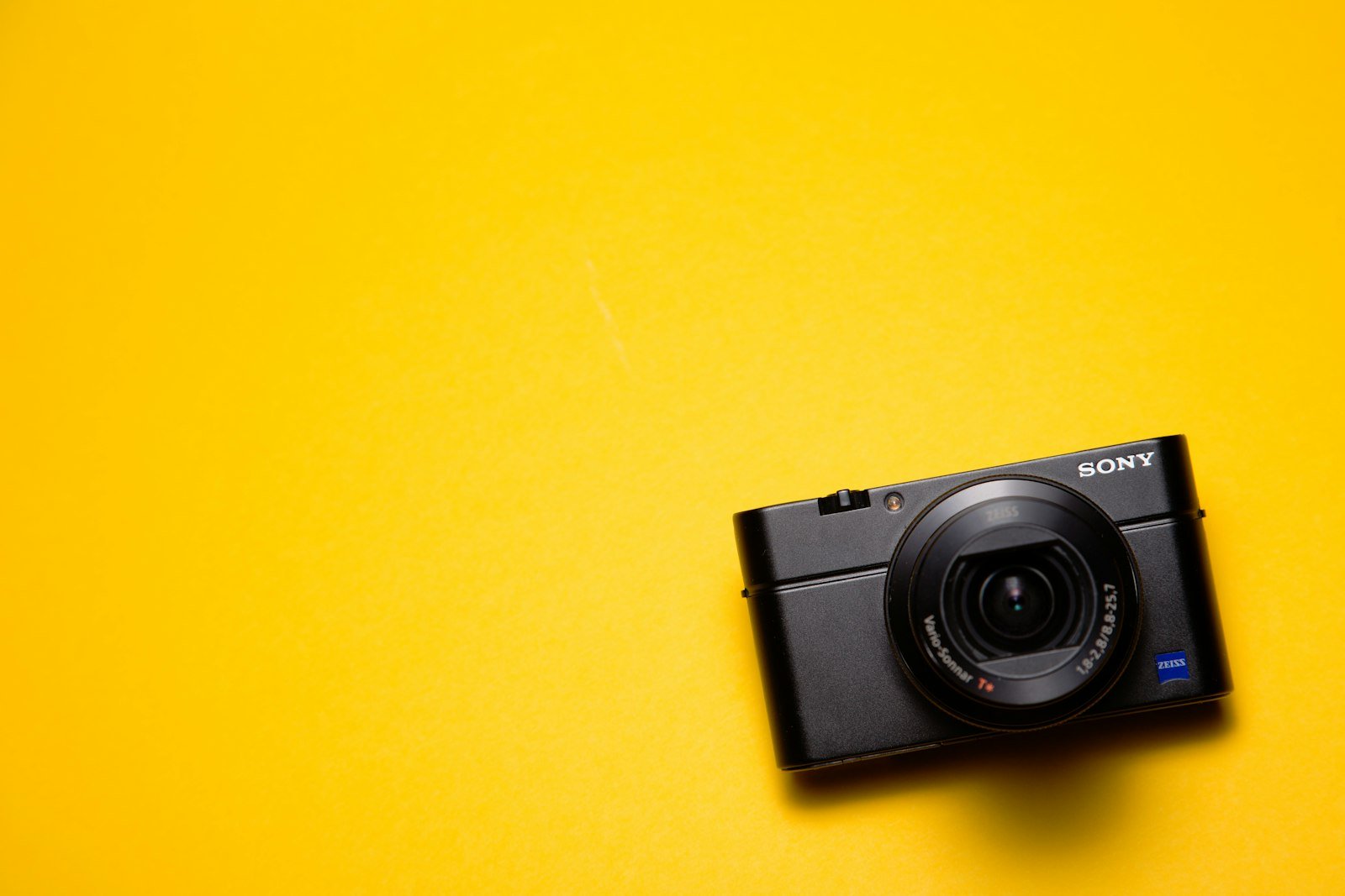 Cámara compacta Sony de la serie RX100 sobre un fondo amarillo