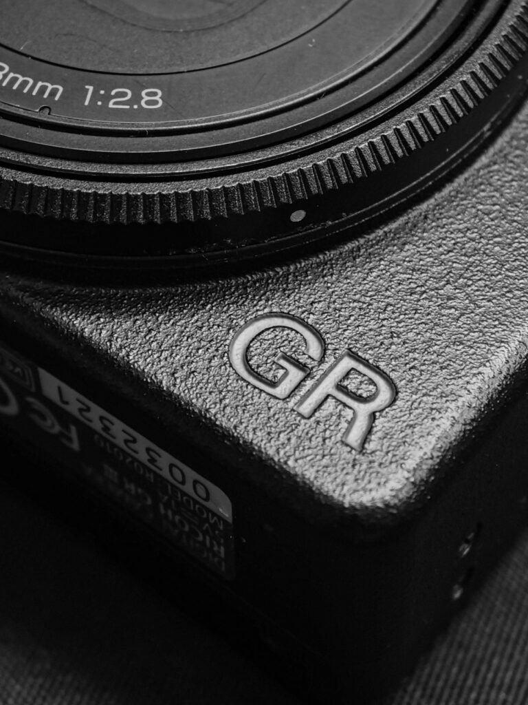 Detalle del cuerpo y el objetivo f/2.8 de una cámara Ricoh de la serie GR