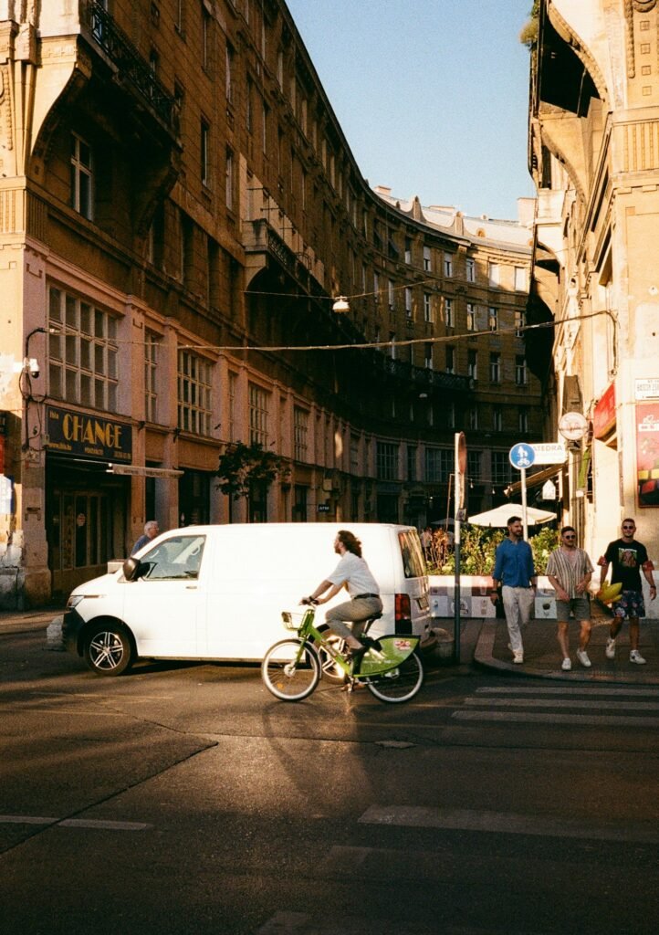 Ciclista cruzando una calle de Budapest con luz cálida de tarde